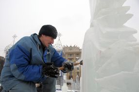 A sculptor works above creation of ice sculpture