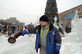 A sculptor works above creation of ice sculpture
