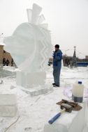 A sculptor works above creation of ice sculpture