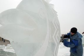 A sculptor works above creation of ice sculpture