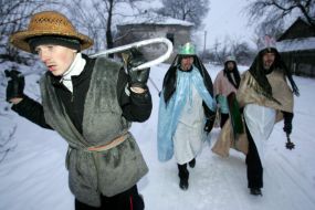 Young people in the suits of fairy-tales heroes are going to sing carols