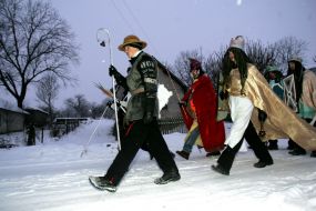 Young people in the suits of fairy-tales heroes are going to sing carols