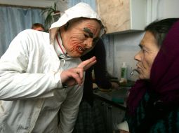 Chrislmas caroler speaks to an old woman