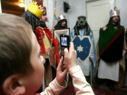 A boy takes pictures Christmas carolers