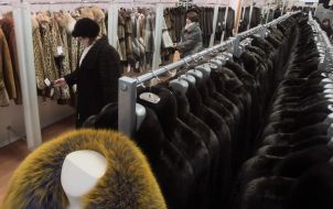A woman chooses a fur coat