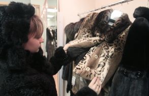 A woman chooses a fur coat