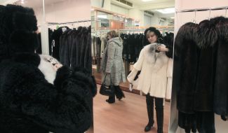 A woman chooses a fur coat