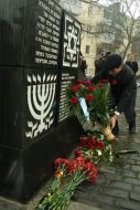 A man lays flowers to the Holocaust victims monument