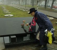 A woman lays flowers to the Holocaust victims monument