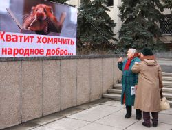 A woman near a placard with Gennady Babenko image