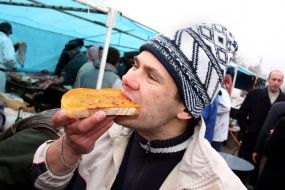 Мужчина кушает хлеб, смазанный свежим смальцем