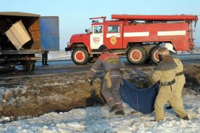 Пожарники несут тело погибшего