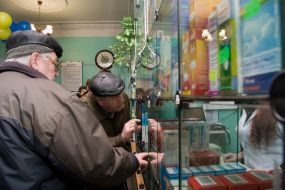 Мужчины покупают лекарства в аптеке