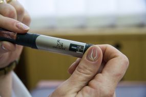 A nurse demonstrates syringe-pen