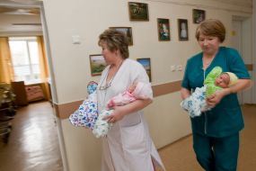 Медсестры несут новорожденных детей матери