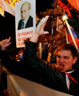 Участники акции держат плакат с изображением Владимира Путина