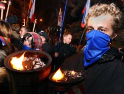 Участники акции несут факела и национальные флаги Российской Федерации