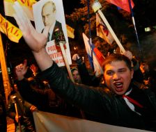 Участники акции держат плакат с изображением Владимира Путина