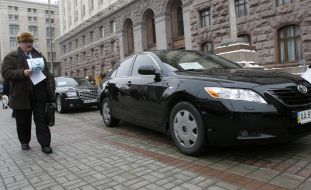 Участник аукциона проходит мимо автомобиля “Toyota Camry”