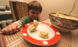 Little boy eats meat dumplings