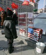 A boy stands near a suitcase