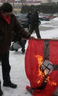 Communist party of Ukraine supporters burn a fascist flag with a swastika
