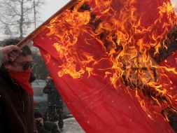 Communist party of Ukraine supporters burn a fascist flag with a swastika