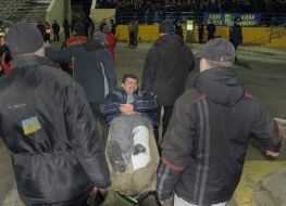 Medical staff take away FC “Metallist” fan on the stretchers from a stadium