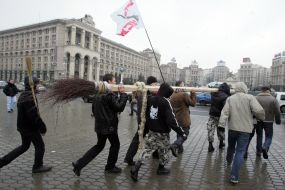 Protest action participants carry a ”scythe” on a broom
