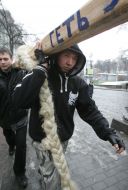 Protest action participants carry a ”scythe” on a broom