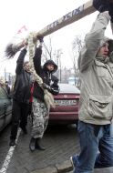 Protest action participants carry a ”scythe” on a broom