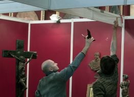 Workers hang sculptures