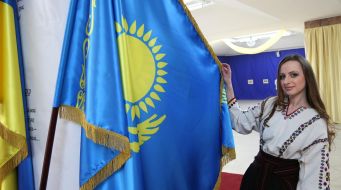 Girl in vyshyvanke near the flag of Kazakhstan