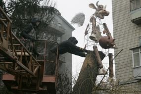 Рабочий устанавливает памятник Летающей корове