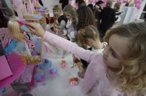 A girl combes of Barbie doll