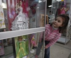 A girl examines of Barbie doll