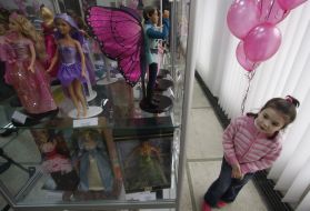 A girl examines of Barbie doll