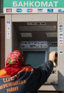Женщина снимает деньги с банкомата