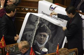 A people’s deputy from KPU hangs a placard with a caricature on President of Ukraine