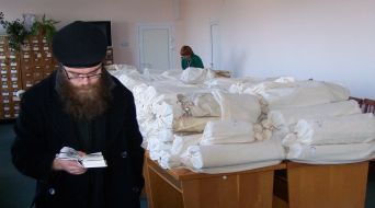 Верующий стоит возле фрагментов свитков Торы