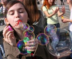 Девушка надувает мыльные пузыри