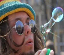 Молодой человек надувает мыльные пузыри