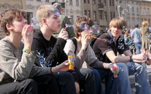 Молодые люди надувают мыльные пузыри