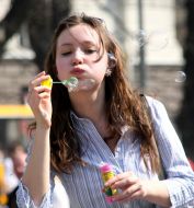 Девушка надувает мыльные пузыри