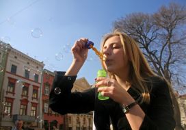 Девушка надувает мыльные пузыри