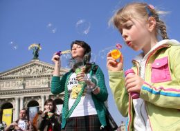 Девочка надувает мыльные пузыри