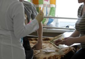 The nurse holds a syringe