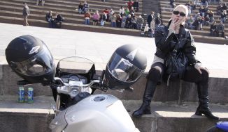 Woman-biker smokes a cigarette