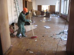 A janitor sweeps glasses of the broken windows in the Moldavia parliament building raided hall