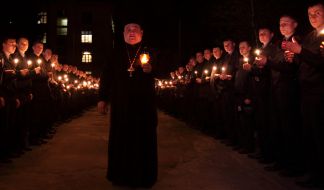 Отец Николай держит лампадку  с Благодатным огнем